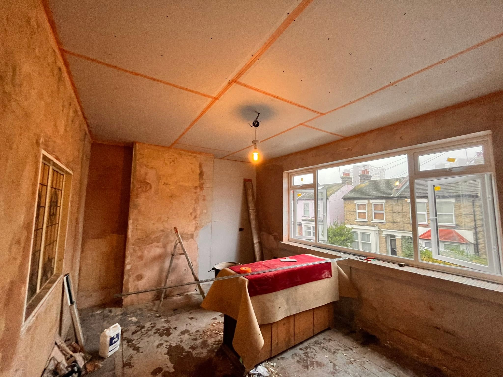 Gez Sayers fitting plasterboard to a ceiling on a job in Southend, Essex